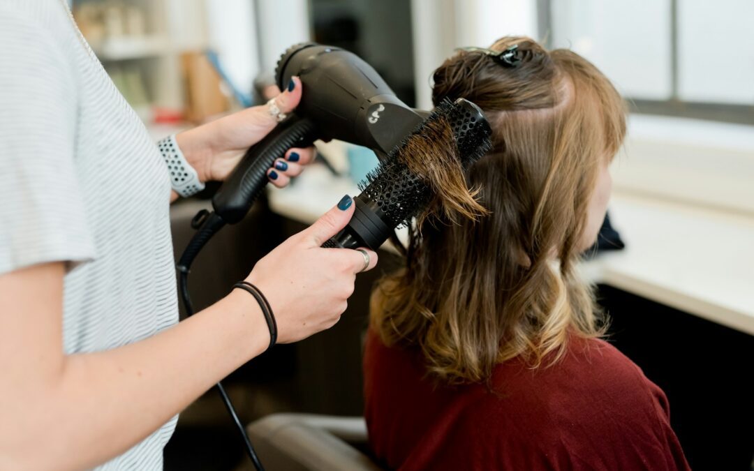 woman in red long sleeve shirt holding hair blower